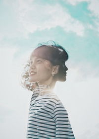 Double exposure of smiling woman against cloudy sky