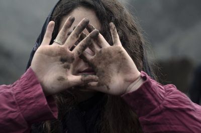 Close-up of young woman showing dirty hands