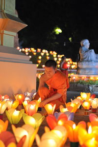 People in illuminated temple at night