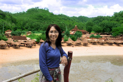 Portrait of smiling young woman standing on land