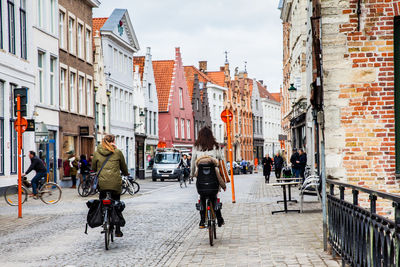 People on street amidst buildings in city