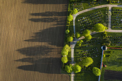 Germany, bavaria, berg, aerial view of plowed field next to countryside cemetery