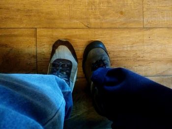 Low section of man standing on hardwood floor