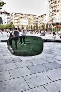 People on street in city against sky