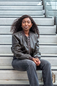 Portrait of young woman sitting on steps