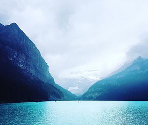 Calm lake against mountain range