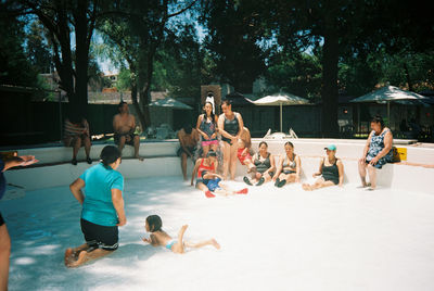 Group of people relaxing by swimming pool