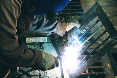 Low angle view of man working on metal