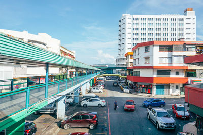 High angle view of cars on road by buildings against sky