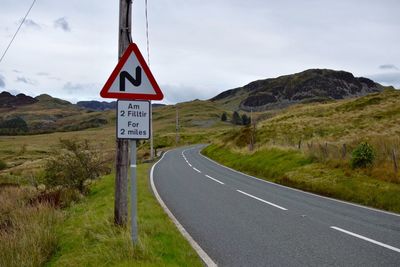 Road sign against mountain range
