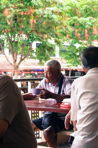 Senior man having food at sidewalk cafe