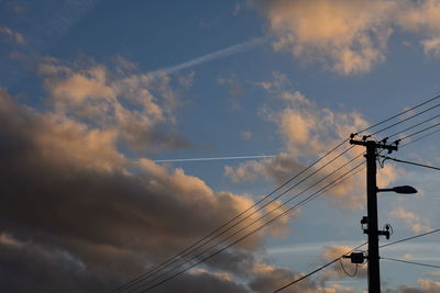 Low angle view of silhouette electricity pylon against sky during sunset