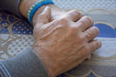 High angle view of woman hand on bed