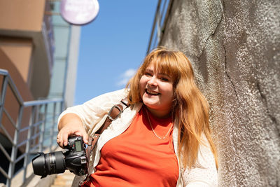 Travel, tourism and entertainment. plus size woman photographer working at the street