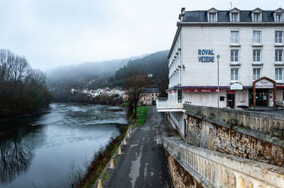 River amidst buildings in city against sky