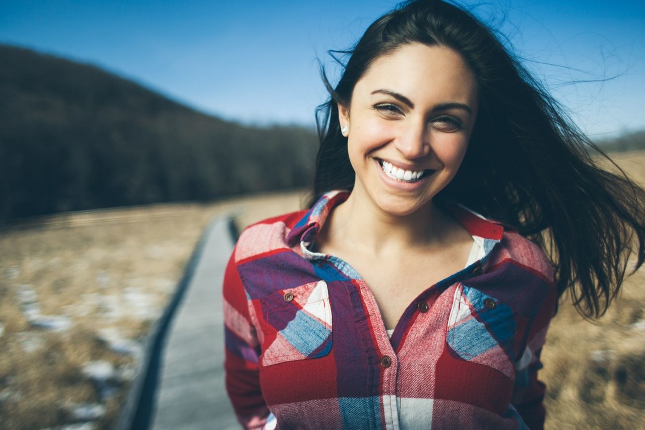 looking at camera, young adult, portrait, person, lifestyles, young women, front view, smiling, leisure activity, casual clothing, focus on foreground, happiness, sunglasses, long hair, toothy smile, headshot, standing