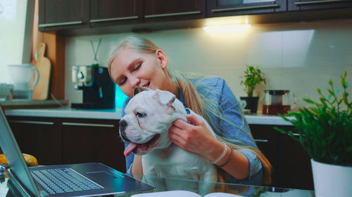 Portrait of young woman using laptop at home