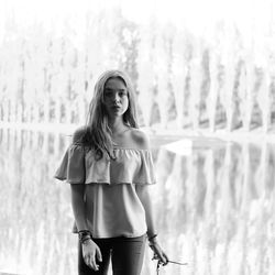 Portrait of teenage girl standing against lake