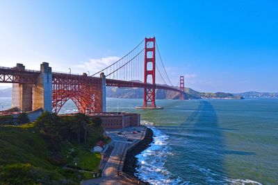 Golden gate bridge over river against blue sky