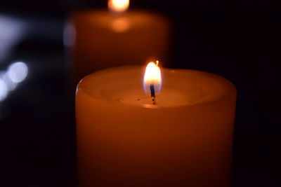 Close-up of lit candle in dark room