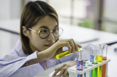 Scientist pouring chemical in test tube at laboratory