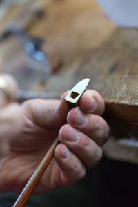 Cropped hands of woman repairing violin string