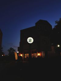 Illuminated clock tower against clear sky at night