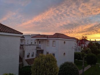 Exterior of buildings in town against sky during sunset