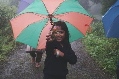 Girl with umbrella standing in rain