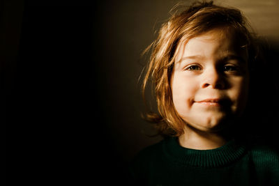 Determined toddler girl standing in bright light smiling