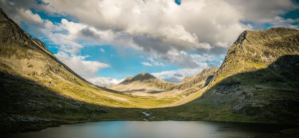 Panoramic view of lake by mountains against sky