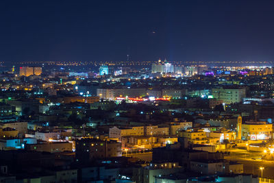 Illuminated cityscape against sky at night