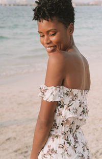 Happy woman standing at beach