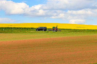 Tractor on agricultural field against sky