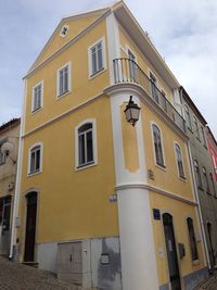 Low angle view of yellow building against sky