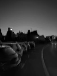 Cars on road against clear sky at night