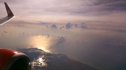 Airplane flying over water against sky