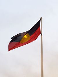 Low angle view of flag waving against clear sky