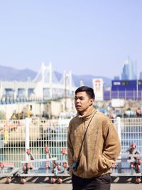 Portrait of young man standing against sky