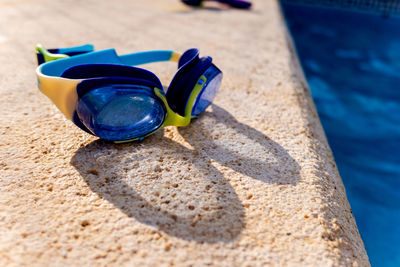 Close-up of swimming goggles on poolside