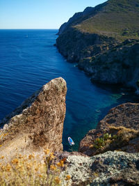 Rock formations by sea against clear sky