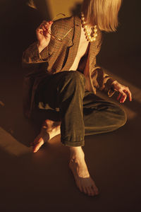 Young man wearing jacket and pearl jewelry at home