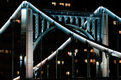 Low angle view of illuminated bridge against sky at night