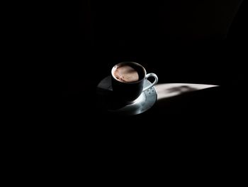Close-up of coffee cup over black background