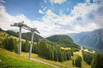 Overhead cable car over mountains against sky