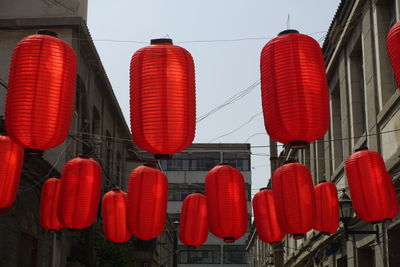 Low angle view of red lanterns hanging against sky