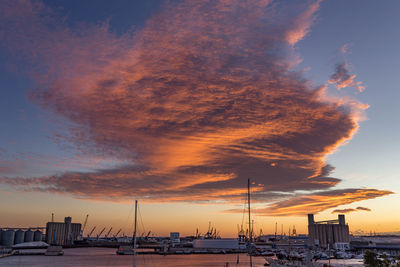 Sailboats on harbor against sky during sunset