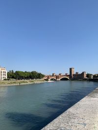 Arch bridge over river against buildings
