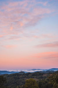 Scenic view of landscape against romantic sky at sunset