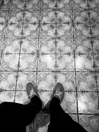 Low section of person standing on tiled floor